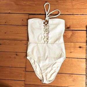 White textured halter top one piece with gold rings along the front